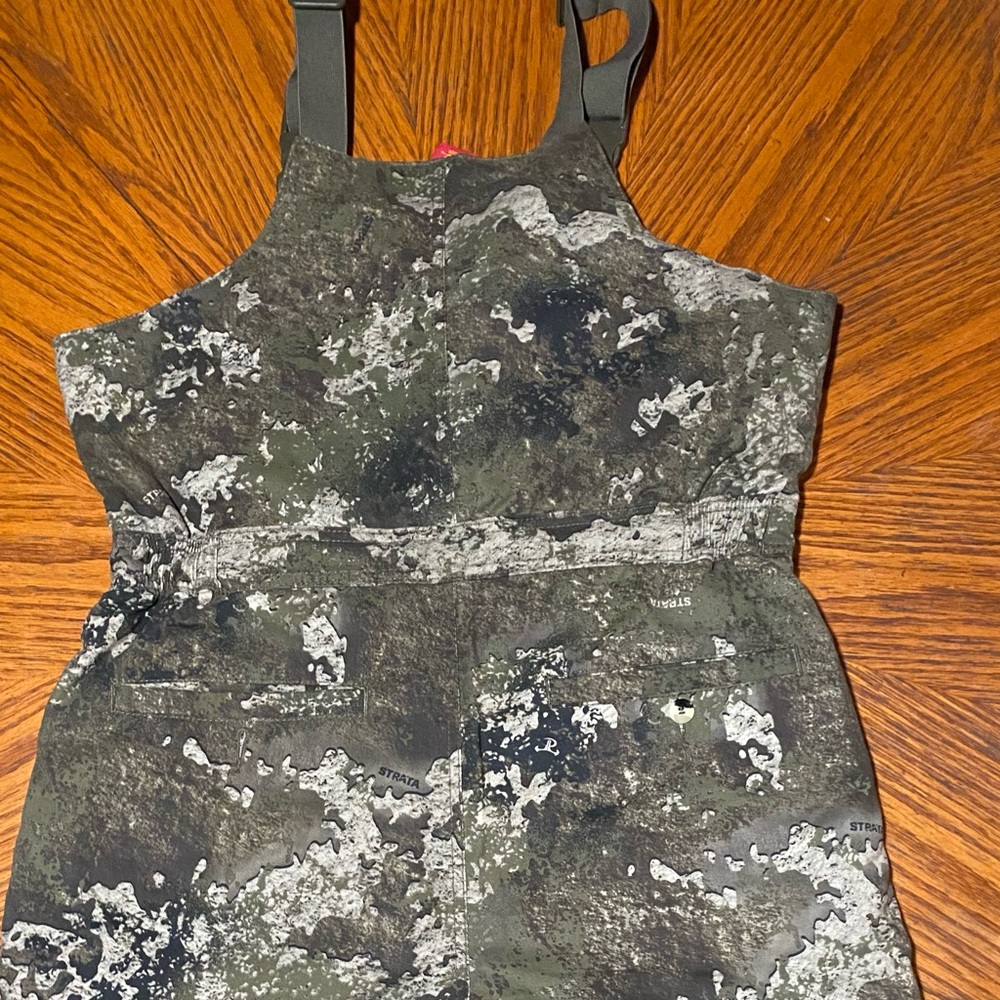 New, without tags Bass Pro Shops Camouflage insulated bibs.